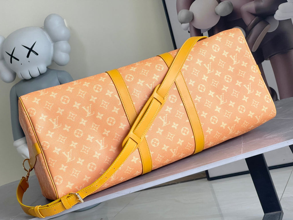 Monogram duffel bag with yellow shoulder strap and gold zipper, front detail