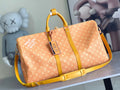 Monogram duffel bag with yellow leather handles and crossbody strap, front view