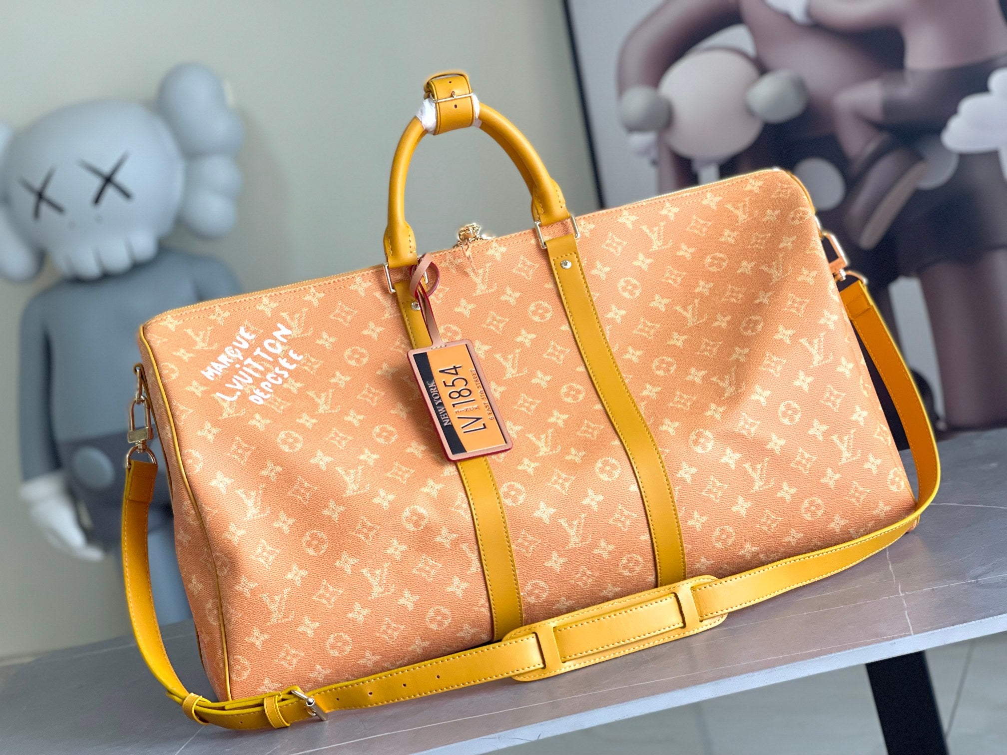 Monogram duffel bag with yellow leather handles and crossbody strap, front view