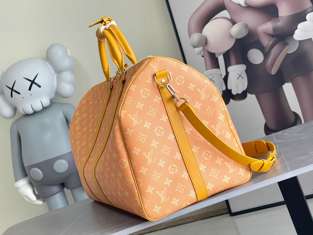 Monogram duffel bag with top handle, yellow strap, and front zipper pocket