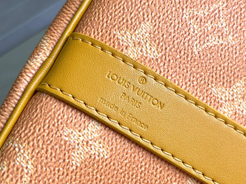 Yellow leather tab with Louis Vuitton logo and edge stitching on monogram canvas