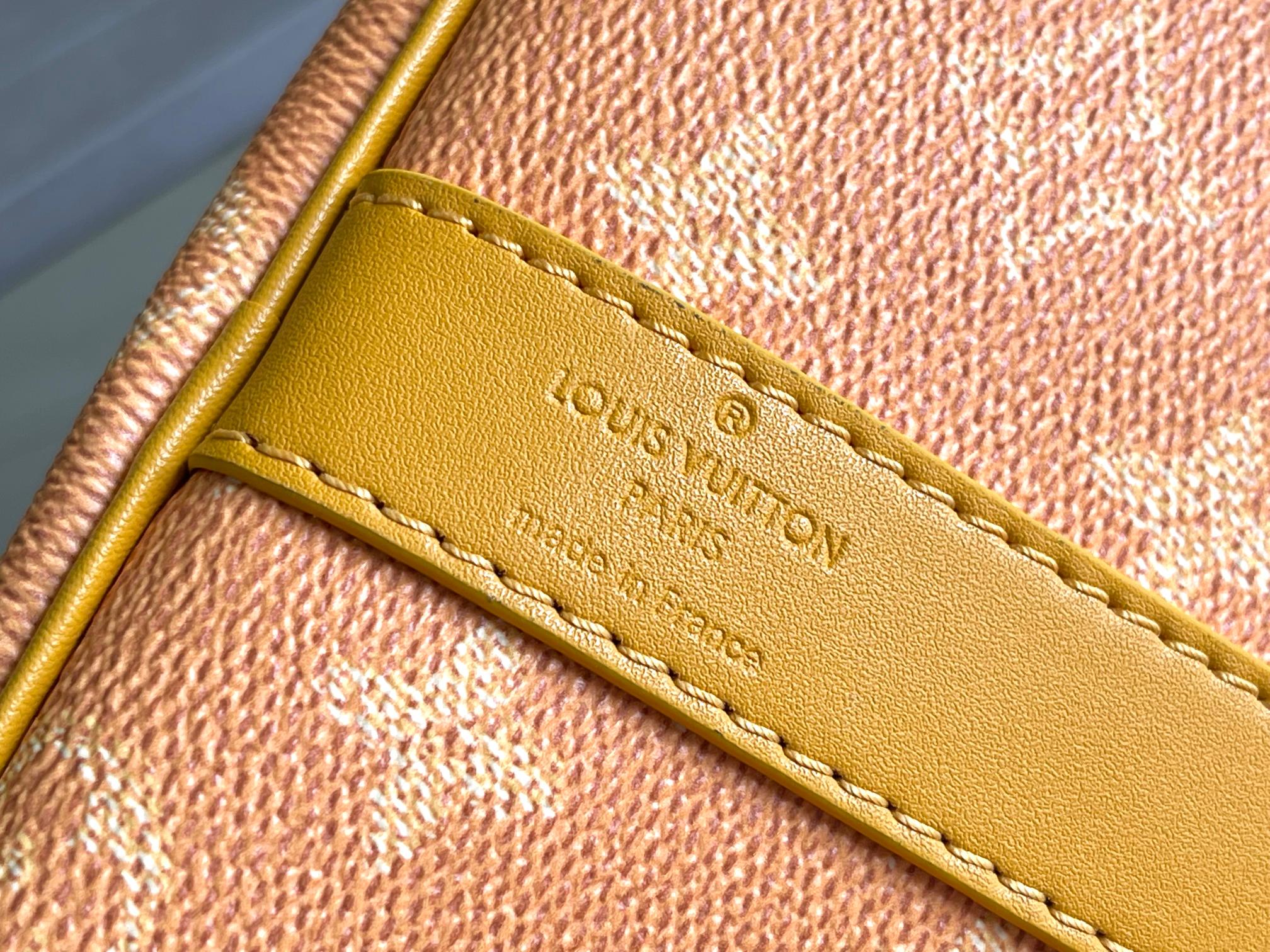 Yellow leather tab with Louis Vuitton logo and edge stitching on monogram canvas