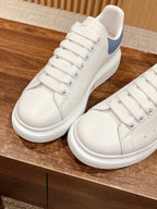 Alexander McQueen white low-top sneakers with blue heel, close-up of laces and side