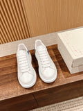 Alexander McQueen low-top sneakers in white with blue accents, lace-up, side view