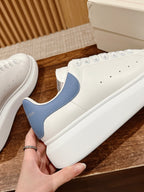 Alexander McQueen white sneakers with blue side panel detail, lace-up, textured upper