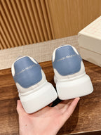 Alexander McQueen white sneakers with blue heel tabs, logo on back, thick rubber sole