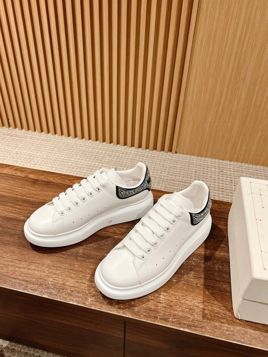 White low-top sneakers with black rhinestone stripe on heel
