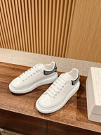White low-top sneakers with black rhinestone stripe on heel