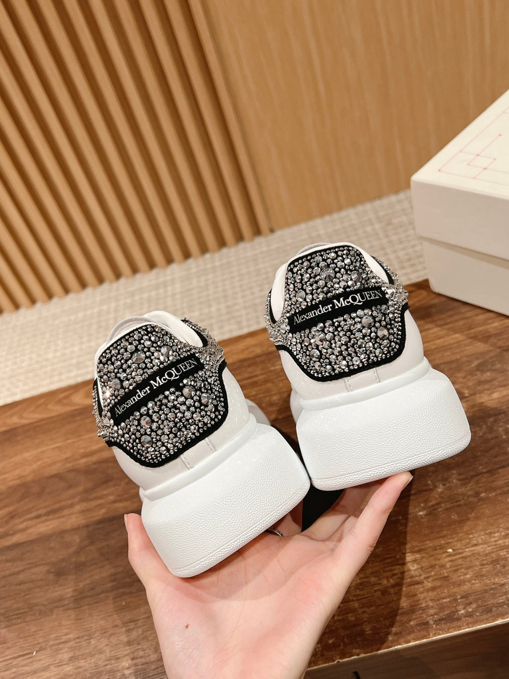 White sneakers showing Alexander McQueen black rhinestone heel tab
