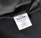 Black coat with white care label reading Prada and Made in Italy
