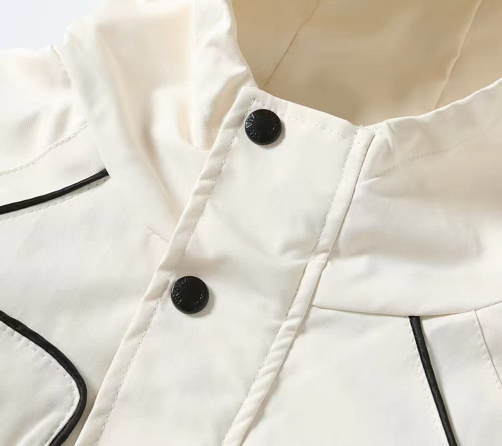 White hooded jacket collar detail with two black snap buttons and black trim
