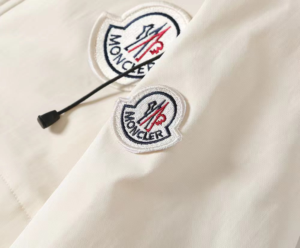 Moncler logo patches on white hooded jacket with black drawstring cords