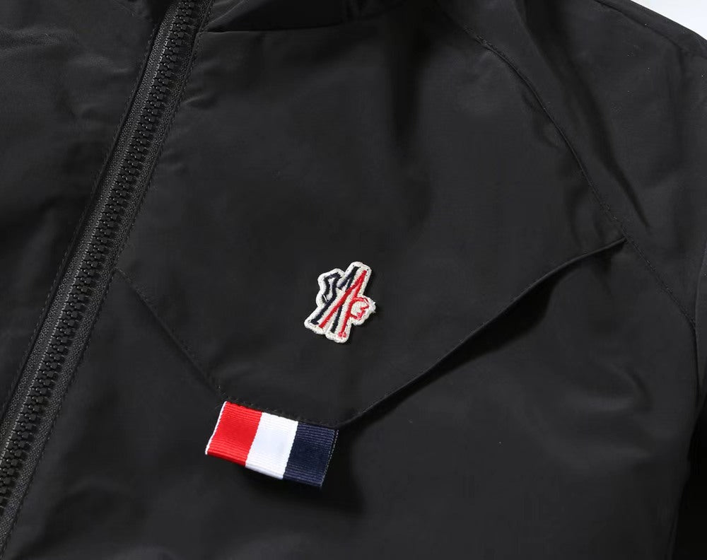 Moncler black jacket detail, chest logo patch near zippered front
