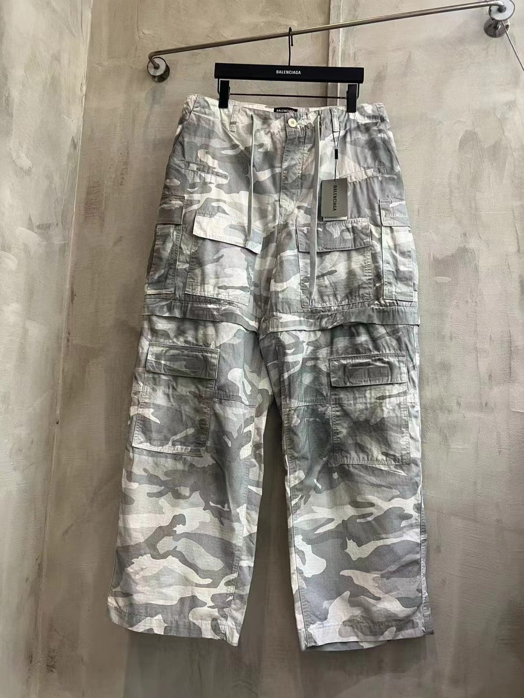 Balenciaga camouflage cargo pants, light gray and white, front view with multiple pockets