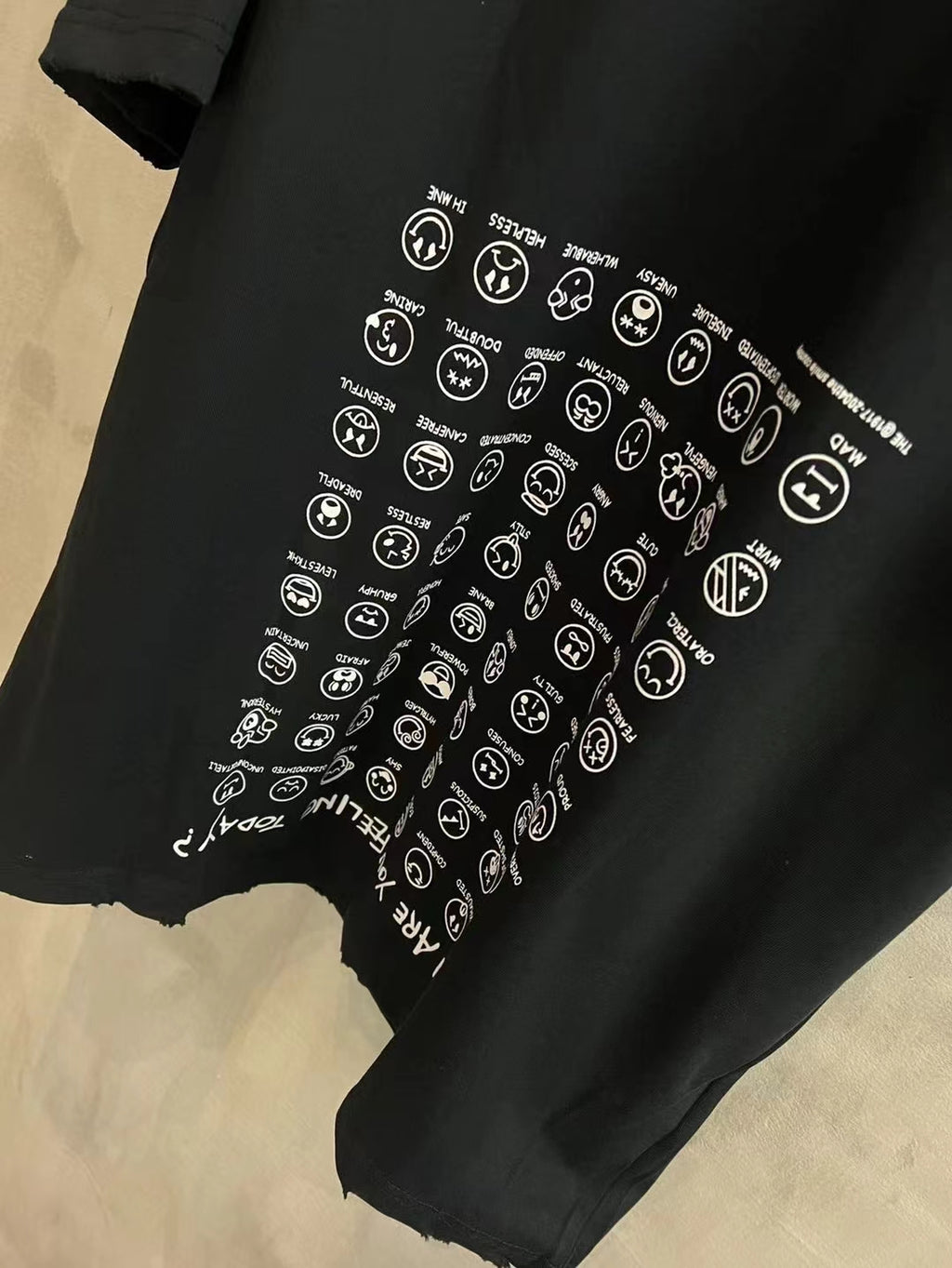 Black T-shirt close-up with white circular logo print detail
