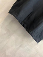 Black T-shirt sleeve and hem with visible stitching detail