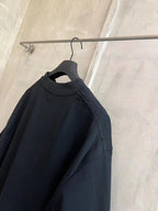 Black crew-neck T-shirt with short sleeves and folded neckline detail