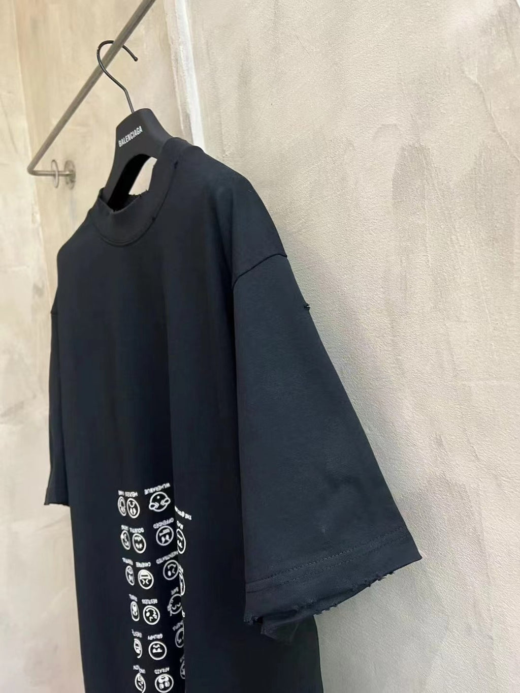 Black crew-neck T-shirt with short sleeves and vertical icon graphic on front