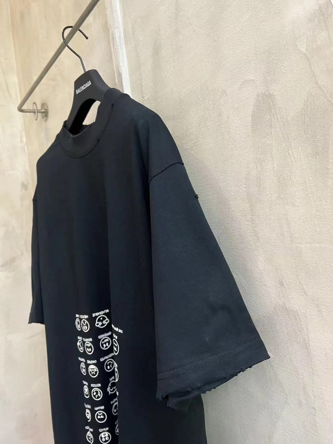 Black crew-neck T-shirt with short sleeves and vertical icon graphic on front