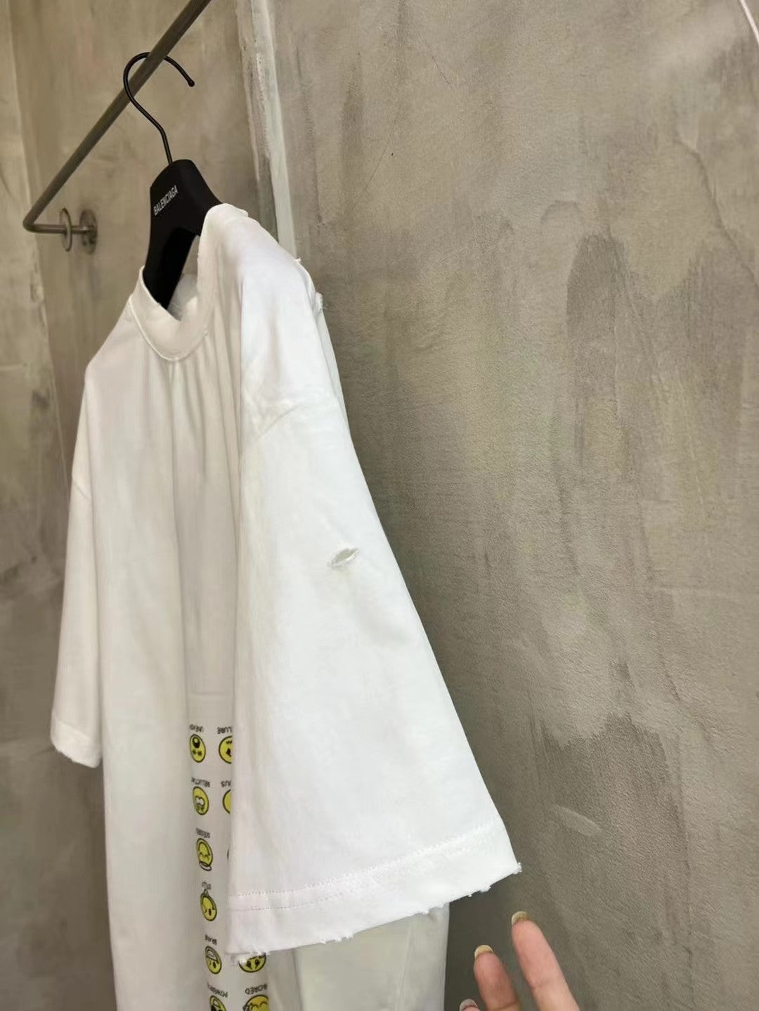 Balenciaga short-sleeve T-shirt, white, side view with partial yellow smiley graphic