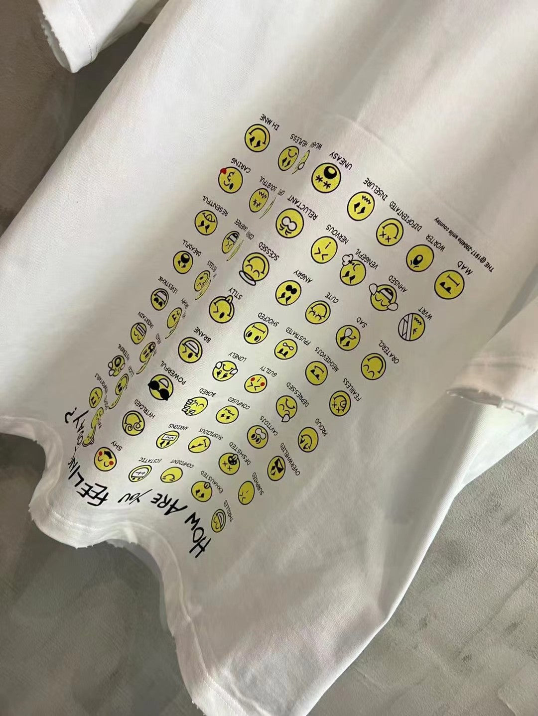 Balenciaga short-sleeve T-shirt, white, graphic section close-up with yellow smileys