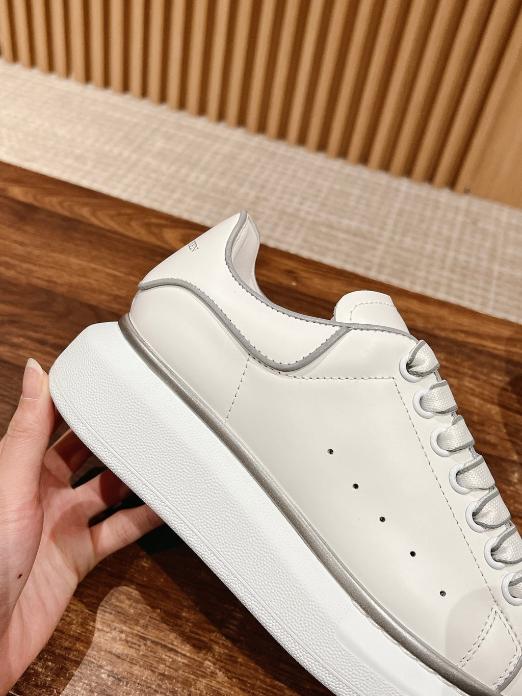 White lace-up sneaker with textured sole edge and stitched toe cap detail