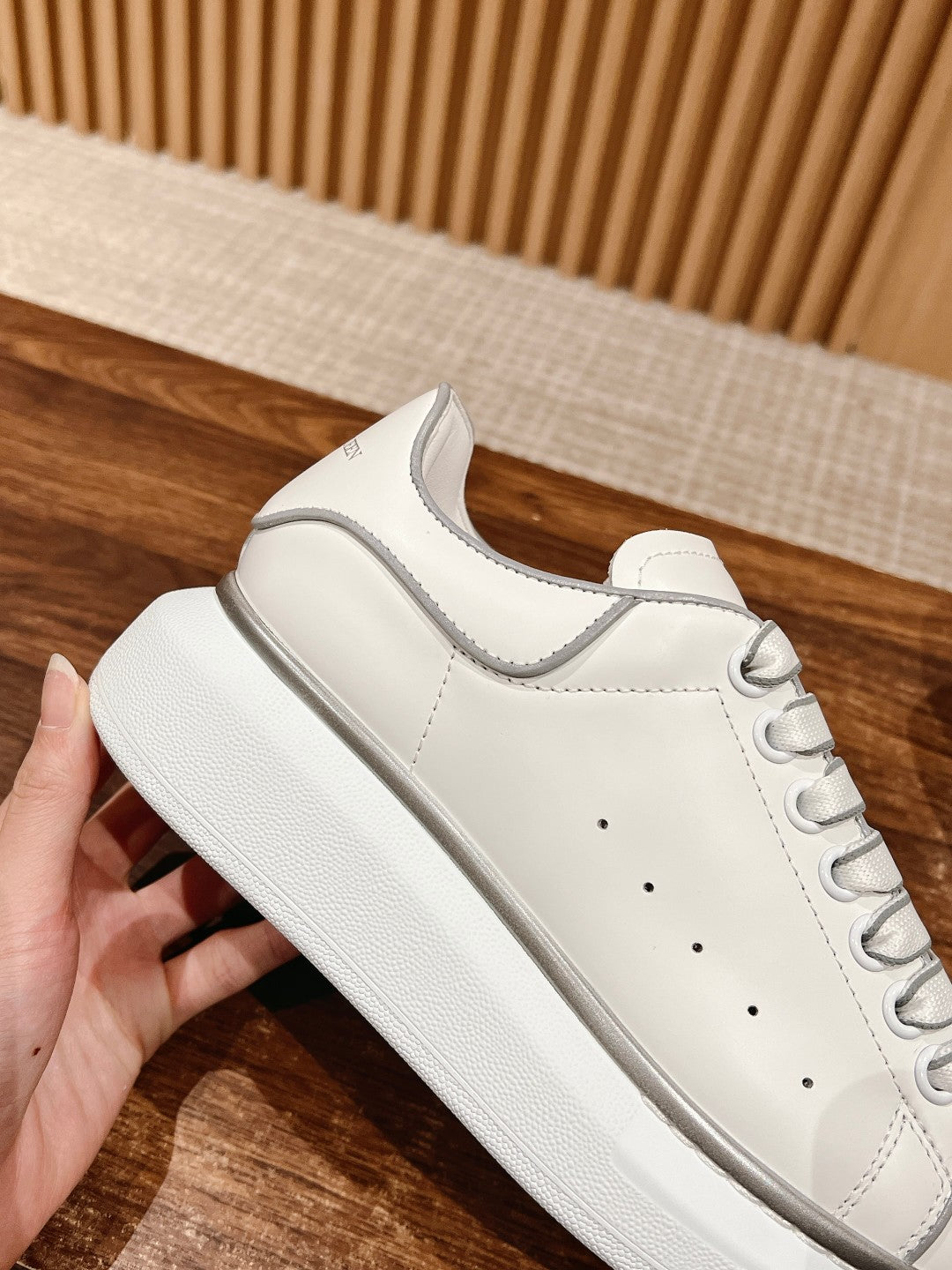 White lace-up sneaker with textured sole edge and stitched toe cap detail