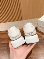 White Alexander McQueen sneakers, back view with heel tab and thick sole