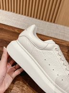 Close-up of white leather sneaker side with lace eyelets and rubber sole