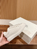 White leather low-top sneakers with lace-up closure and thick rubber sole
