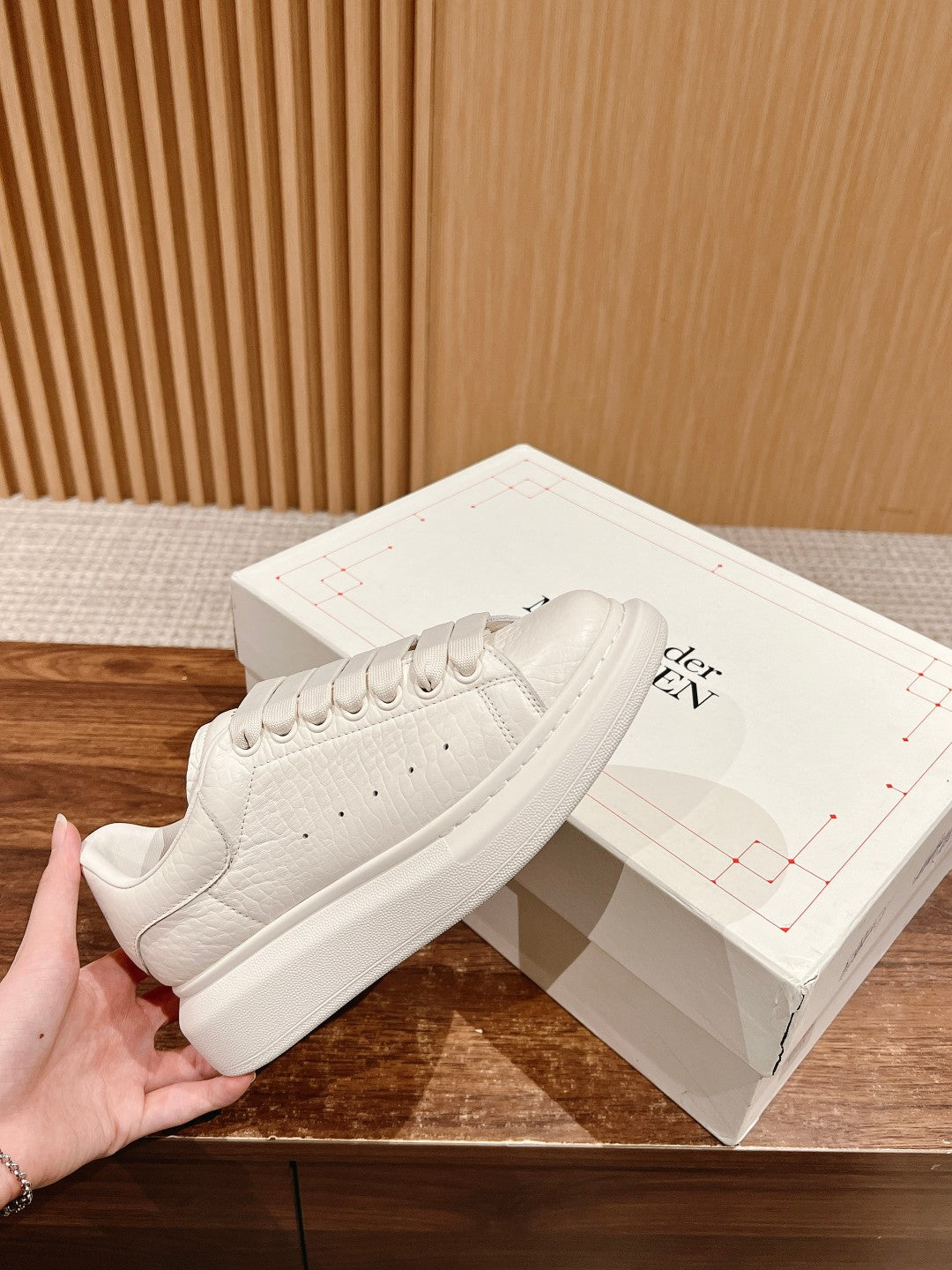 White leather low-top sneakers with lace-up closure and thick rubber sole