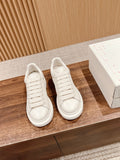 Pair of white leather low-top sneakers with lace-up straps
