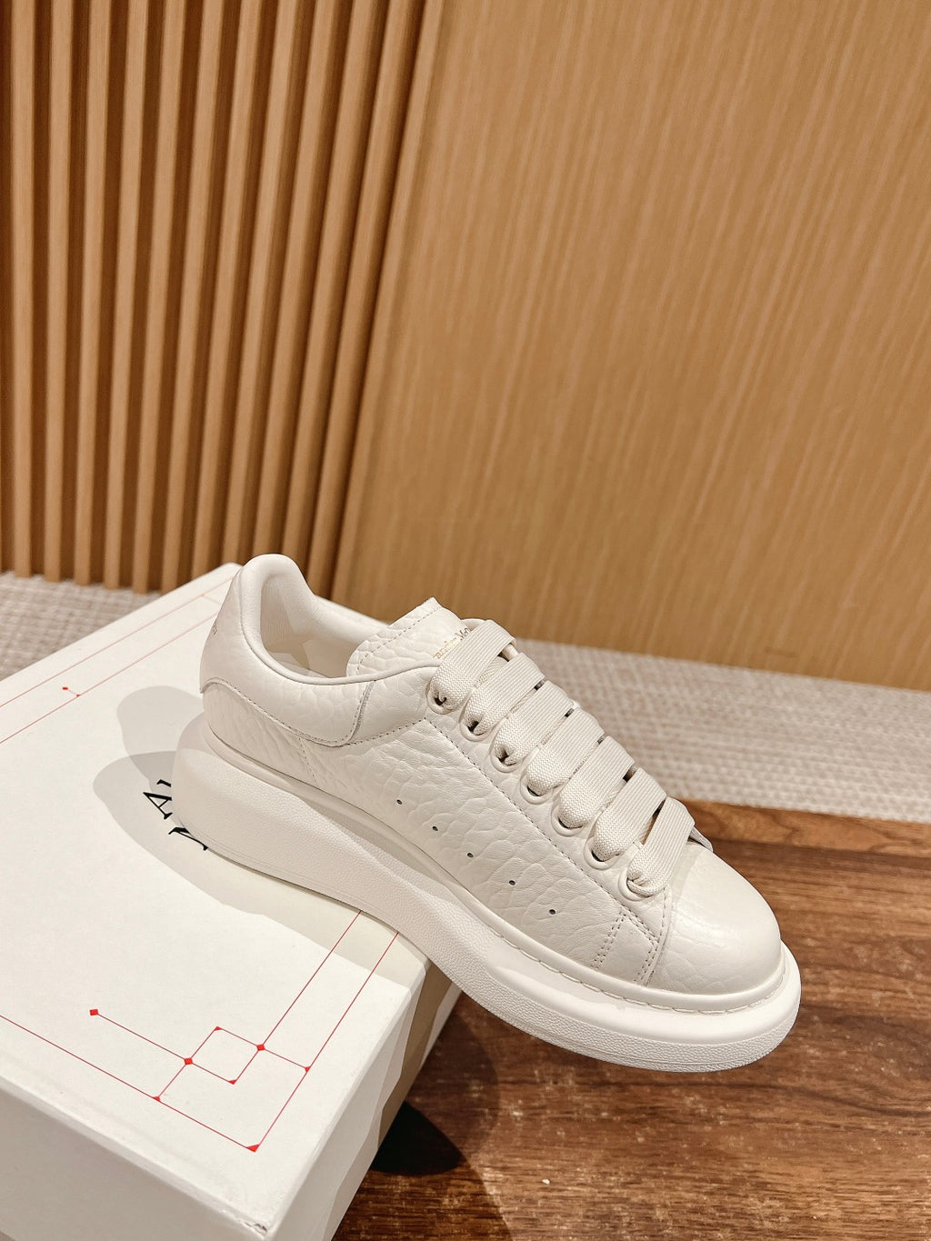 White leather low-top sneakers with lace-up front and smooth rubber sole