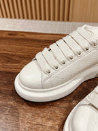 White leather lace-up sneaker with ridged laces and flat rubber outsole