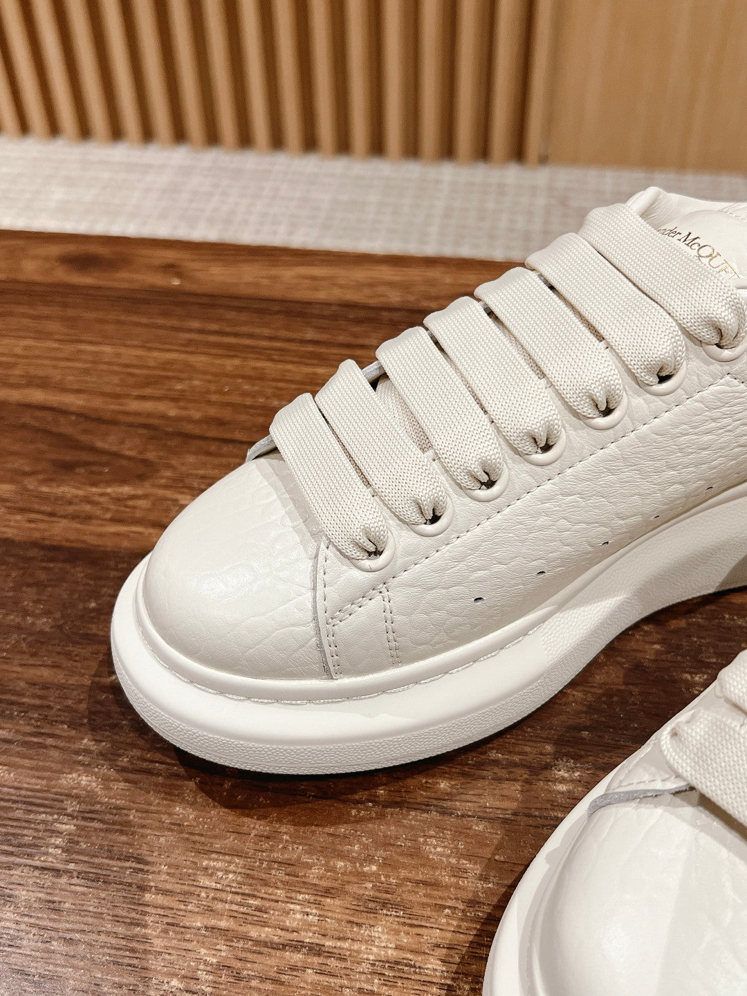 White leather lace-up sneaker with ridged laces and flat rubber outsole