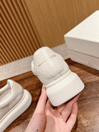 White leather sneaker heel with embossed branding and chunky rubber sole