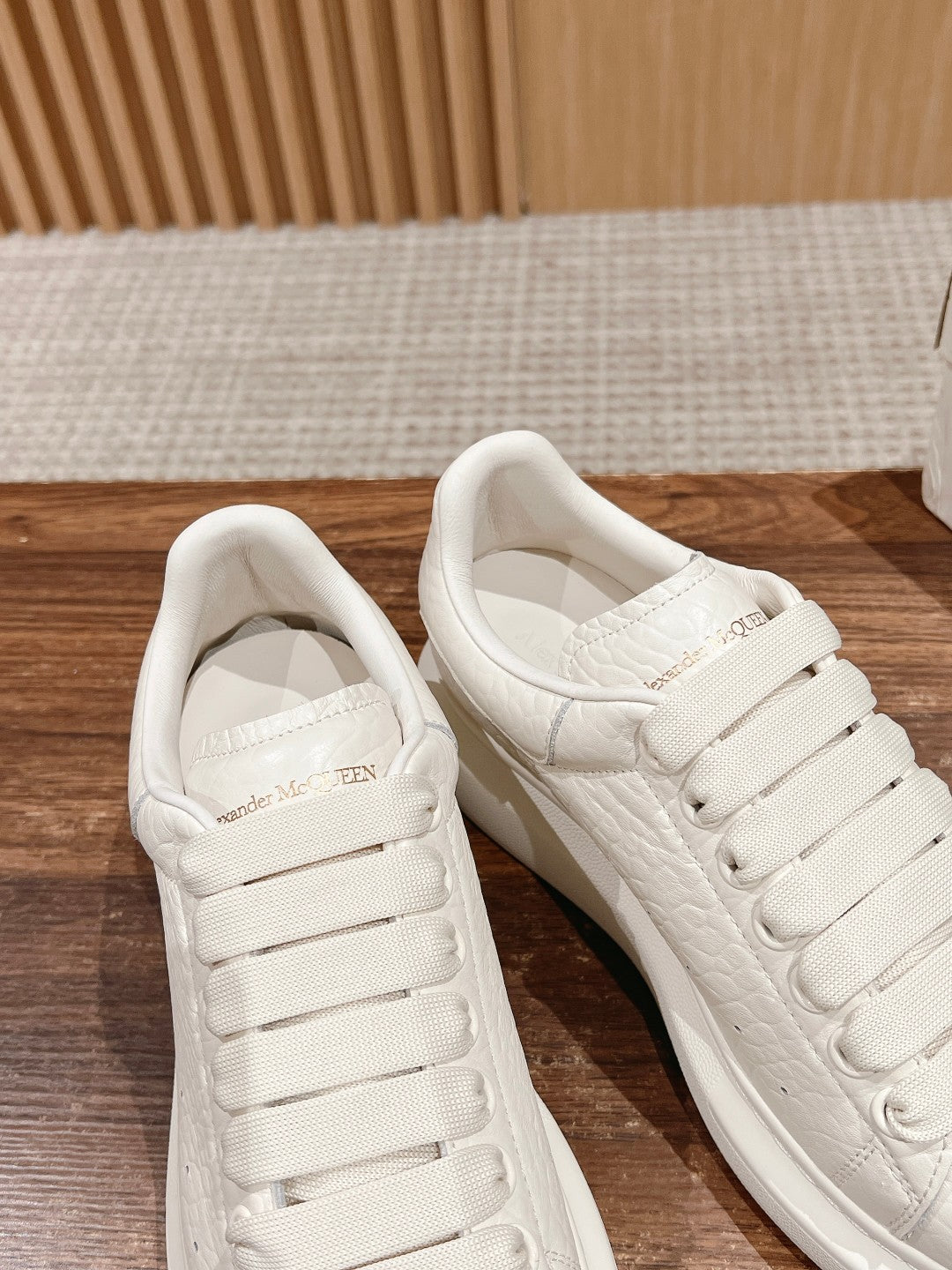 White leather low-top sneakers with padded collars and lace-up design