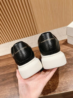 Black leather sneakers with Alexander McQueen logo on heel and white rubber sole