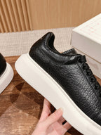 Black leather lace-up sneaker with thick white sole and side texture