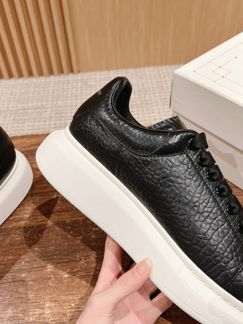 Black leather lace-up sneaker with cushioned collar and white platform sole
