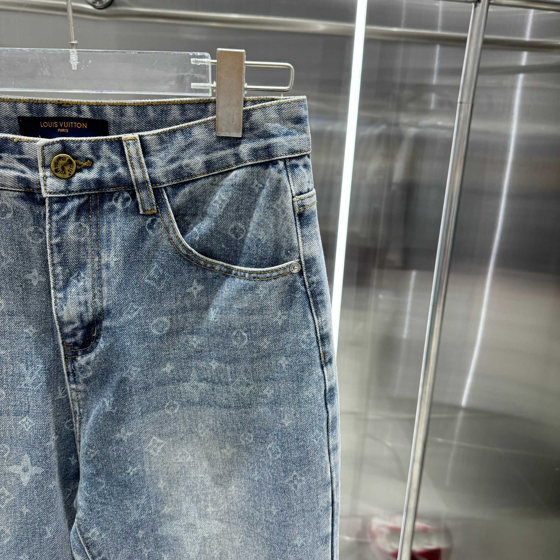 Louis Vuitton blue denim pants side view, monogram pattern, front pockets, belt loops