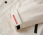 Prada long jacket sleeve close-up with red Prada brand fabric tab
