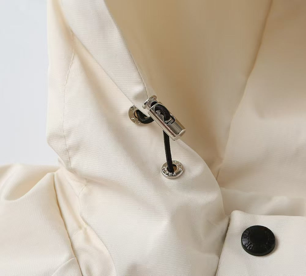 Prada long jacket zipper pull close-up with metal hardware and black accent