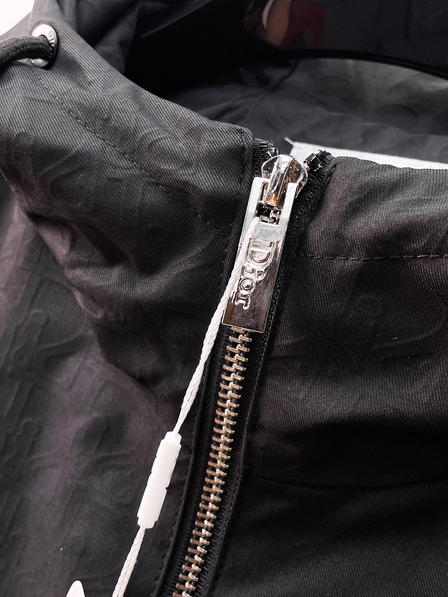 Dior long jacket, close-up of black zipper tape and hooded jacket fabric