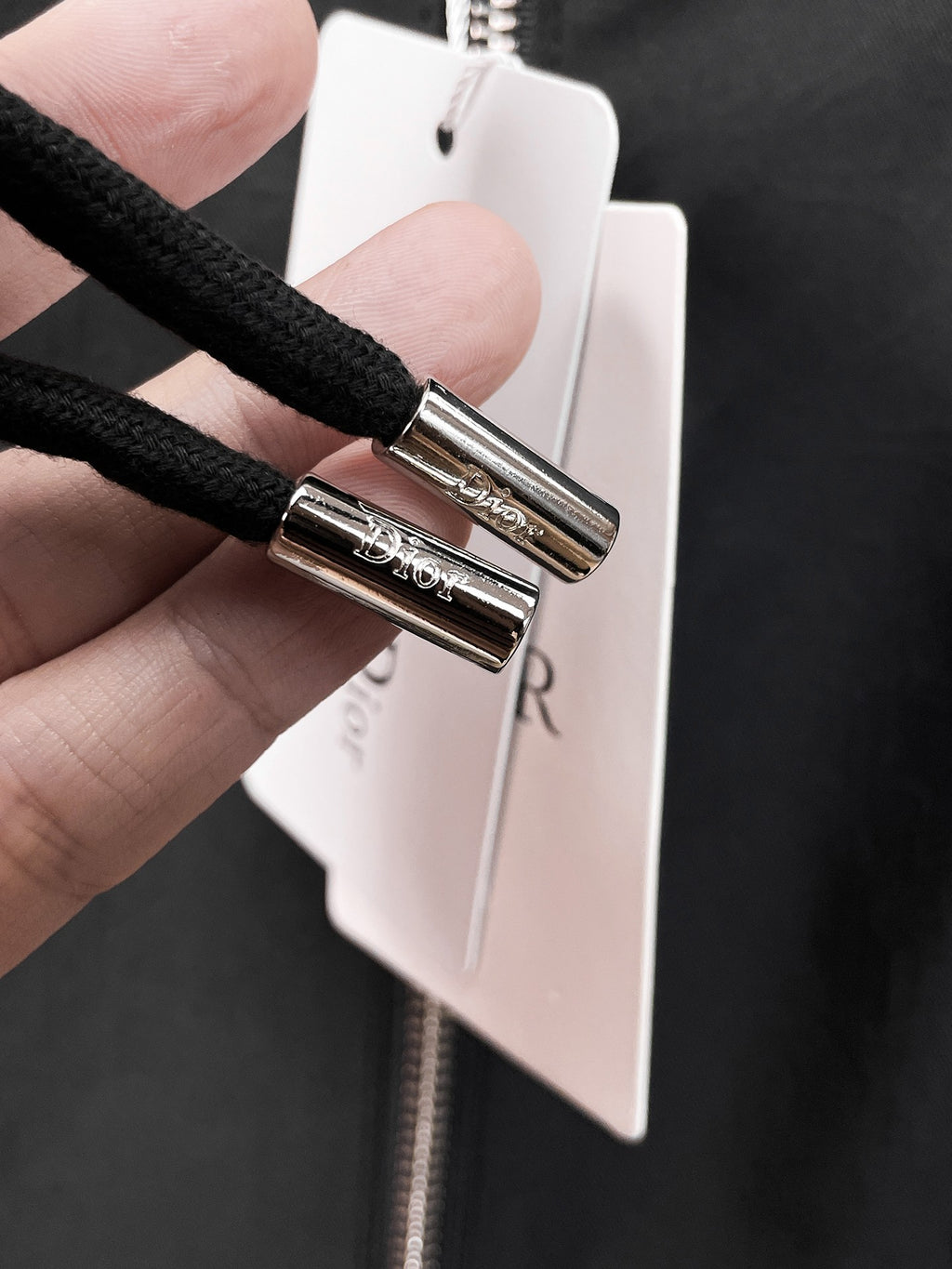 Dior long jacket, close-up of zipper pull and metal slider with hanging tag