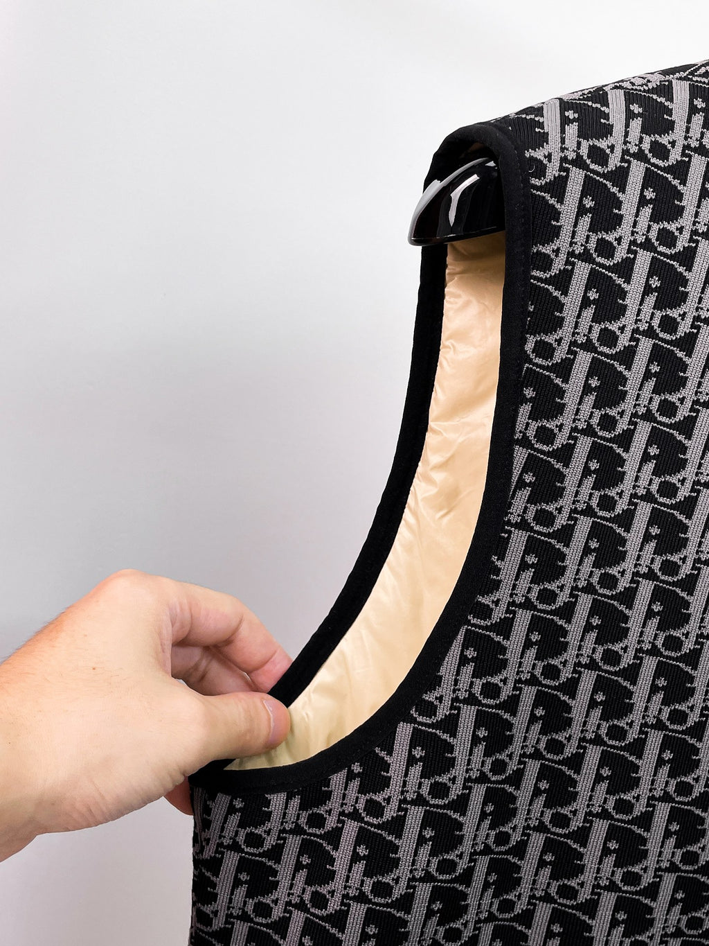 Close-up of black sleeveless vest neckline edge and beige lining