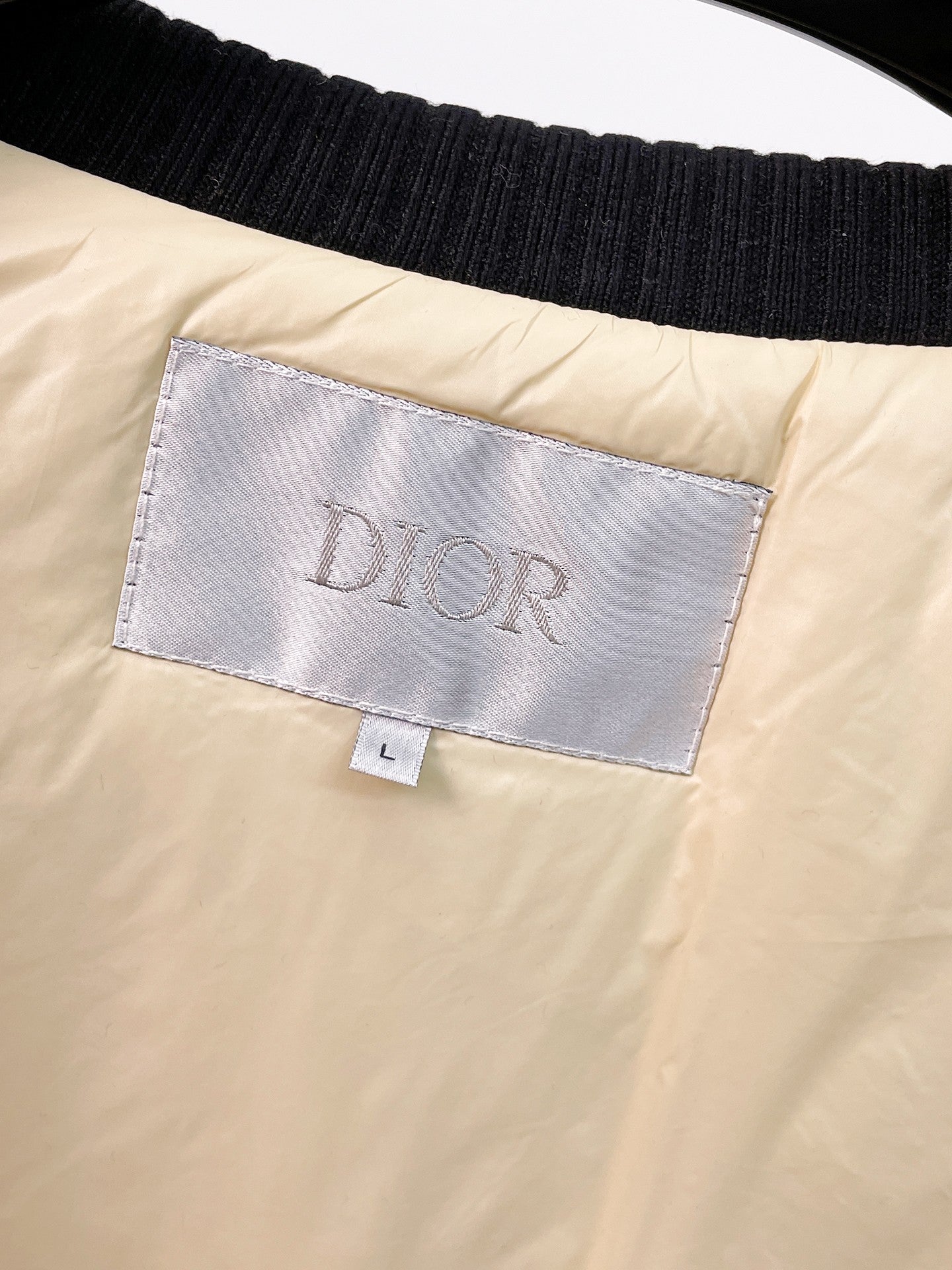 Inside neck label on beige sleeveless vest, size tag visible