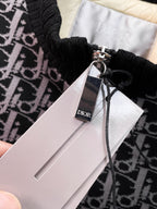 Dior logo hang tag attached to black monogram vest with zipper pull