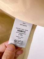 Care and materials label on beige sleeveless vest: 100% cotton, Italy
