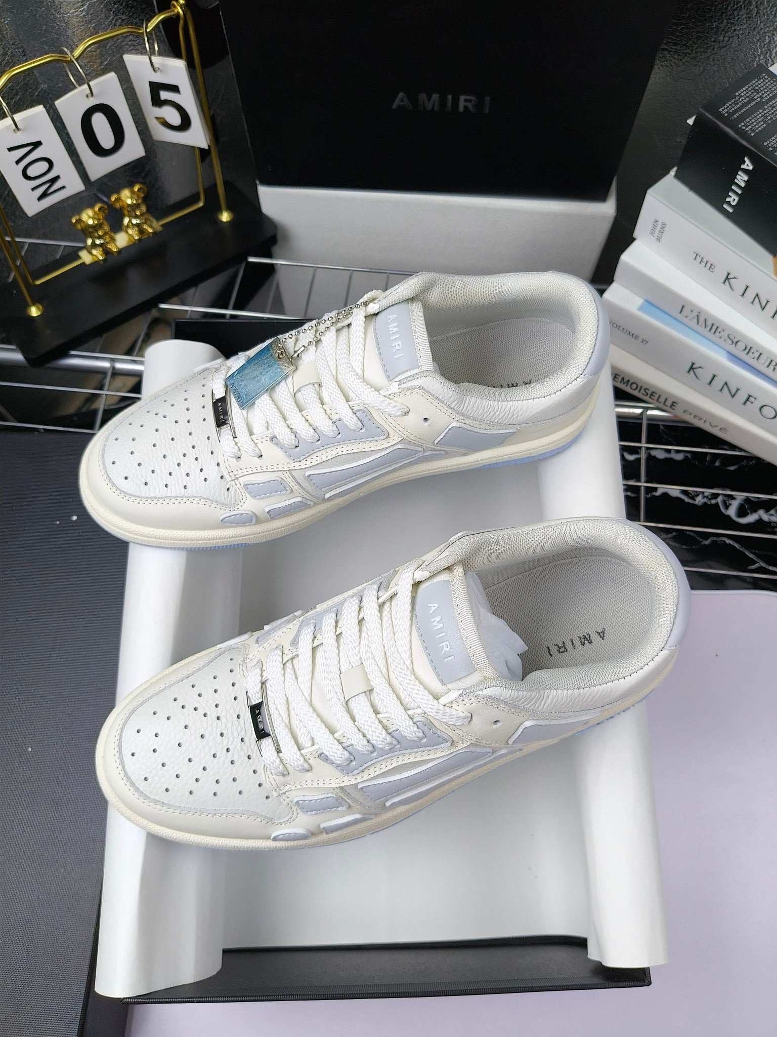 Amiri lace-up sneakers pair, white leather with light-blue panels and perforated toe